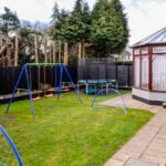 Enclosed family rear garden with childrens swings, football nets, trampoline, playhouse and conservatory